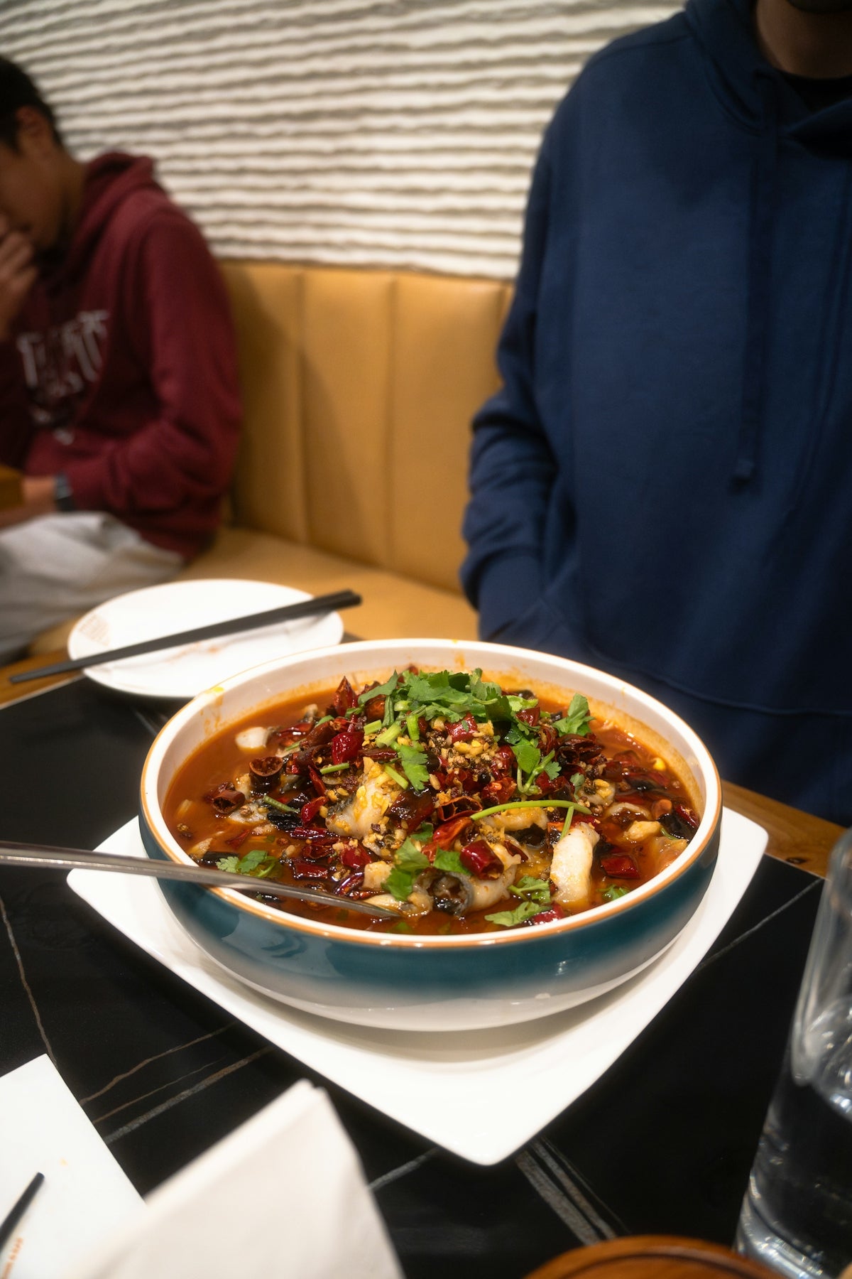 A bowl of spicy fish stew with chili and herbs